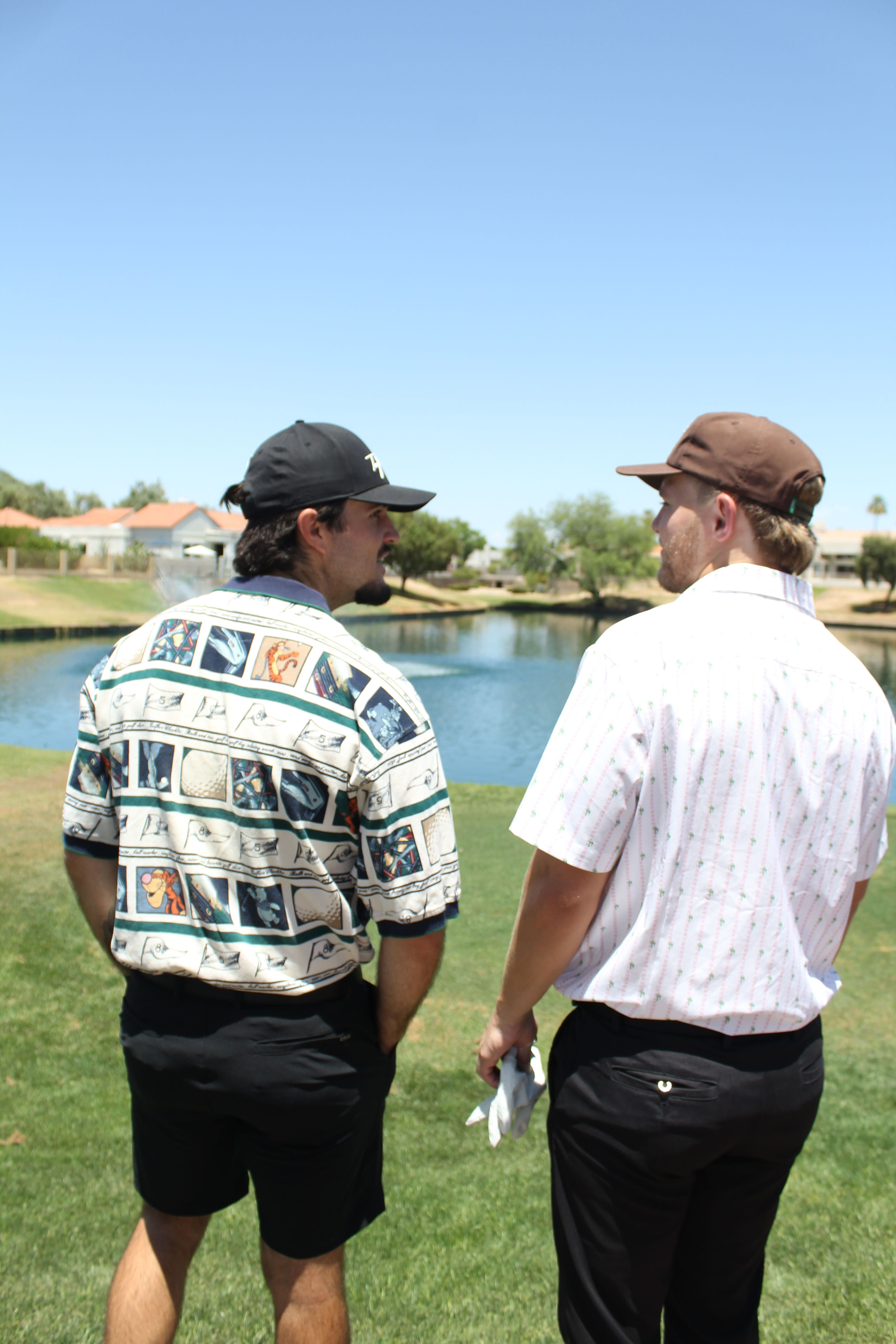 two men in golf attire on golf course